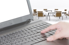 会议背景在一个会议室背景的笔记本电脑打字的商人手中